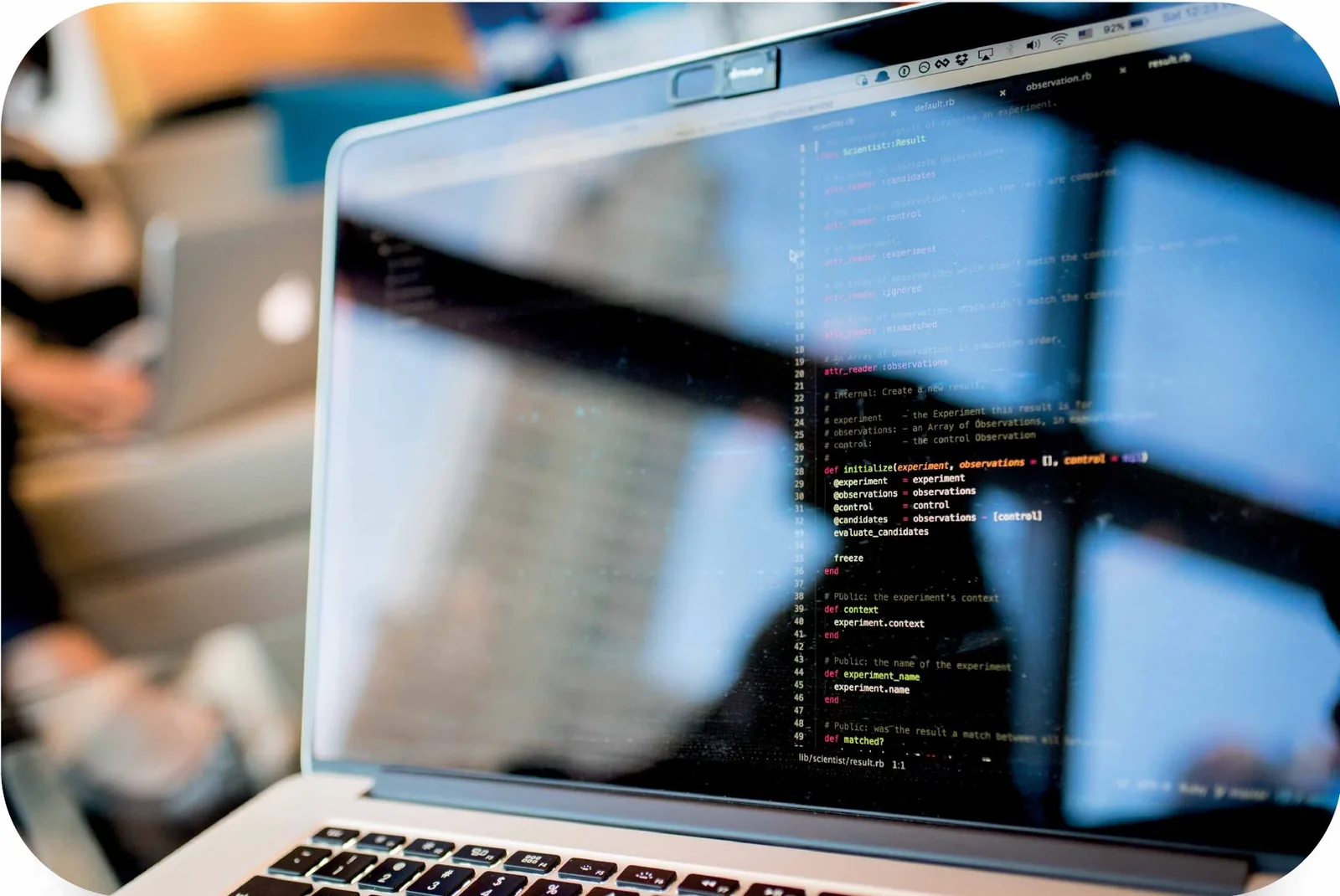 A laptop screen showing source code in a bright office
